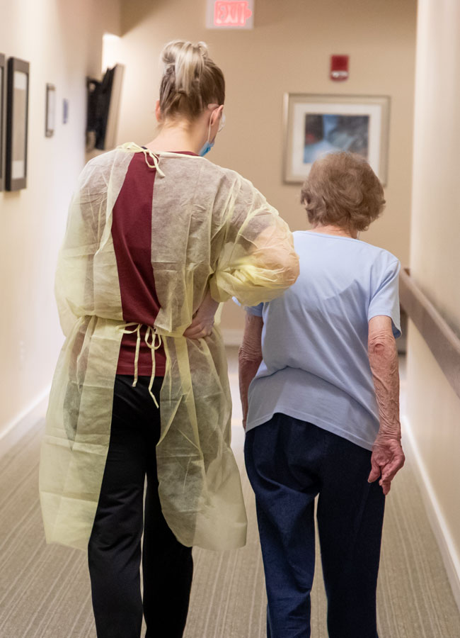 Home Health Nurse assisting elderly patient with disease process management