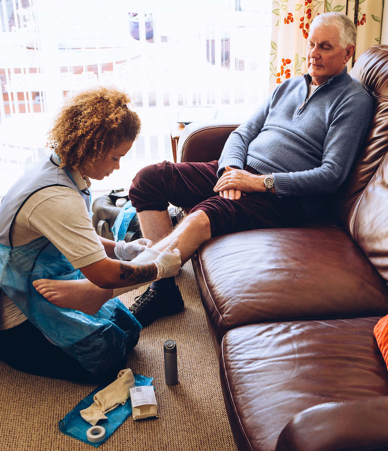 A nurse assisting a patient with wound care.